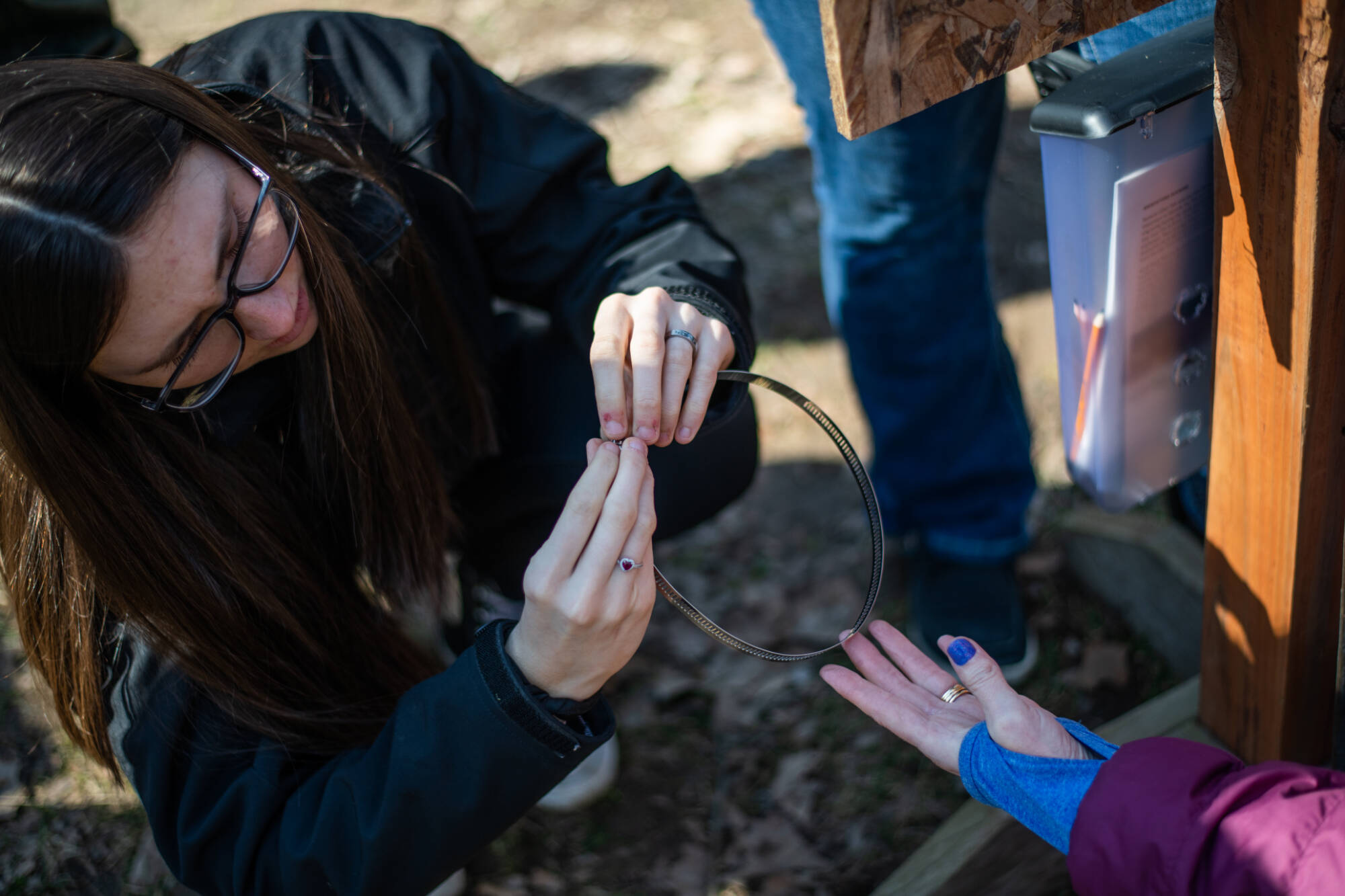 A person is holding and looking at a metal ring of wire